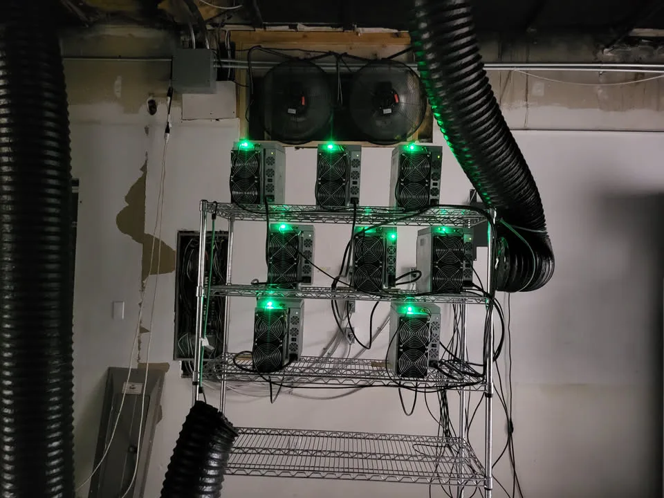 Antminer ASIC Bitcoin miners on wire shelves with ducted cooling fans