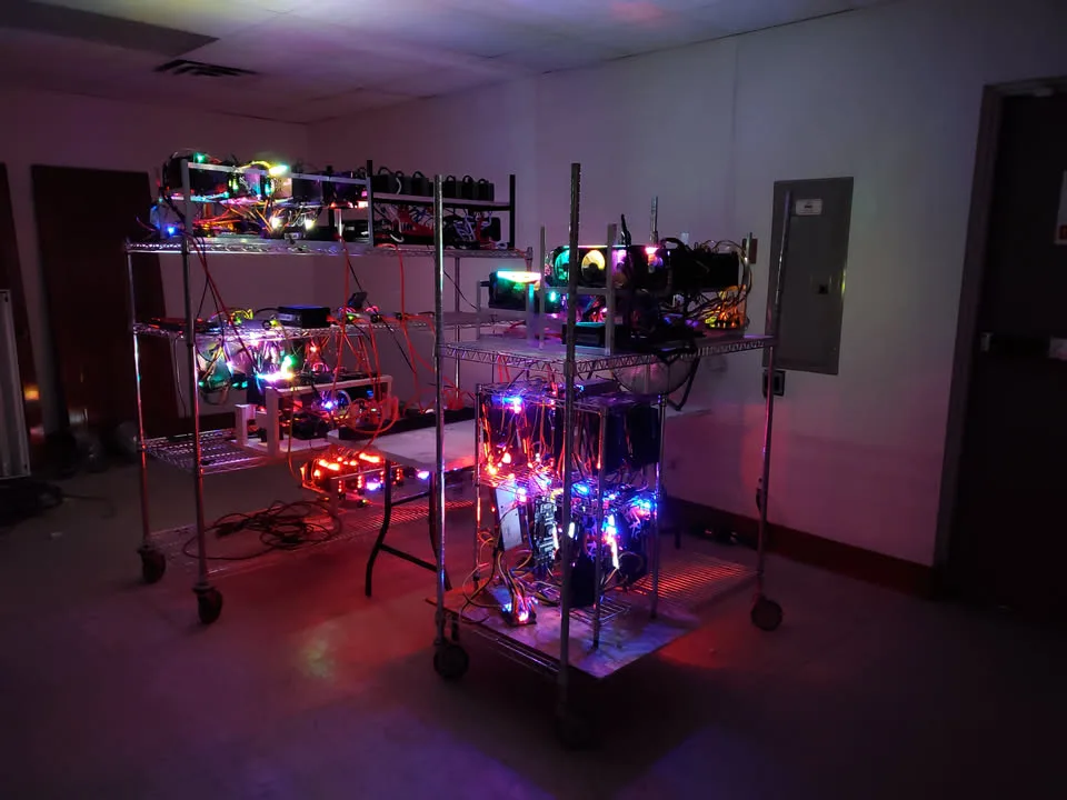 GPU mining rigs glowing at night on rolling wire racks